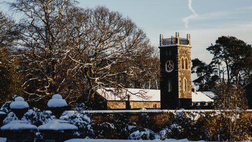 Wide view of the Clock Tower from Rowallane House in the snow at Rowallane Garden
